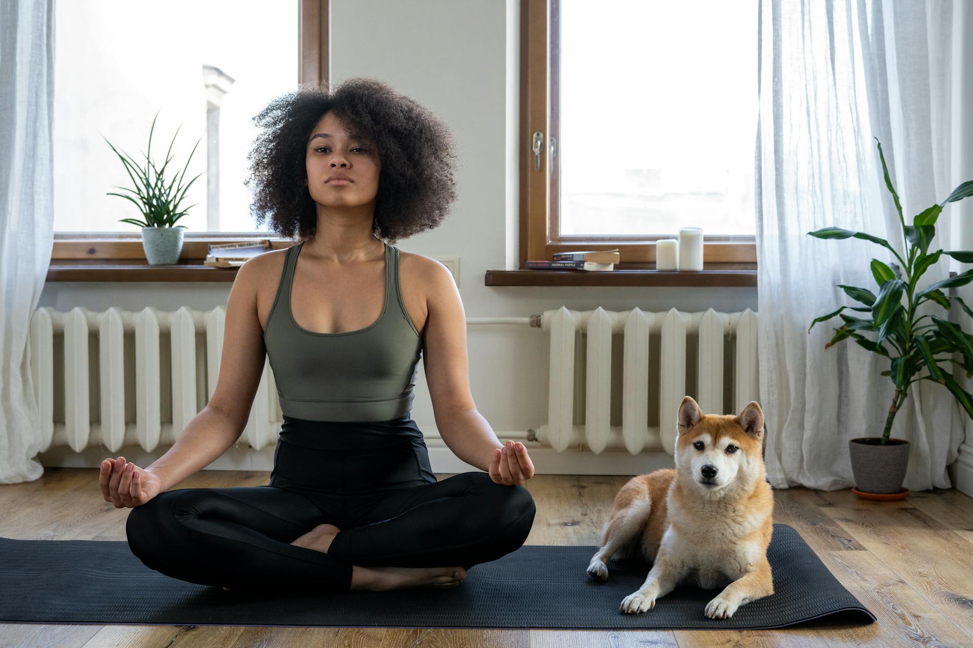 Woman meditating next to her dog.